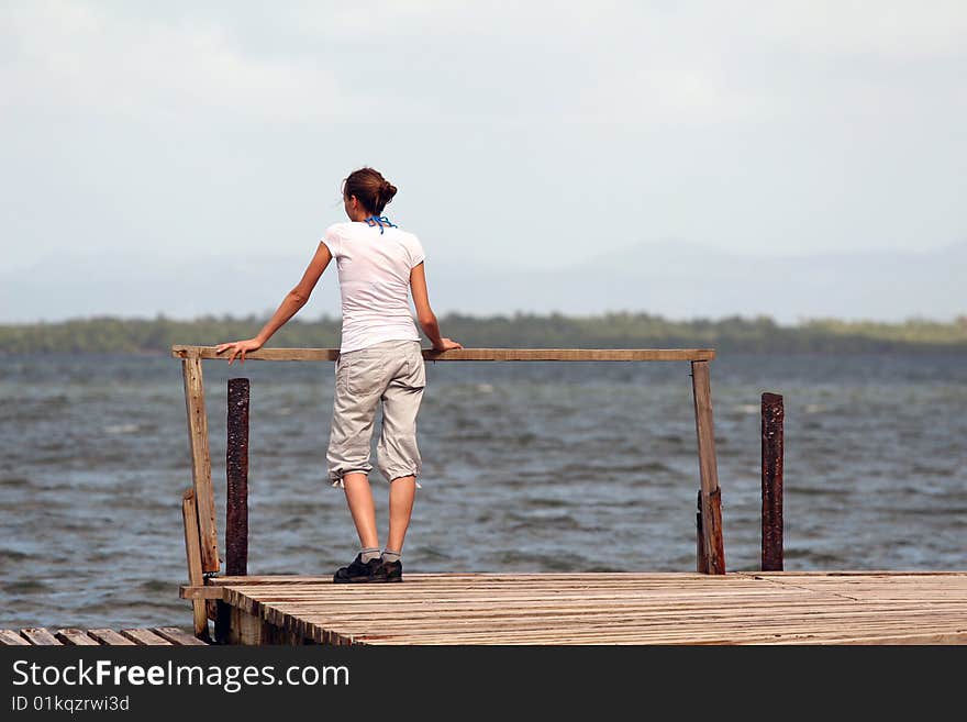 Woman standing on the wooden pier at caribbean sea