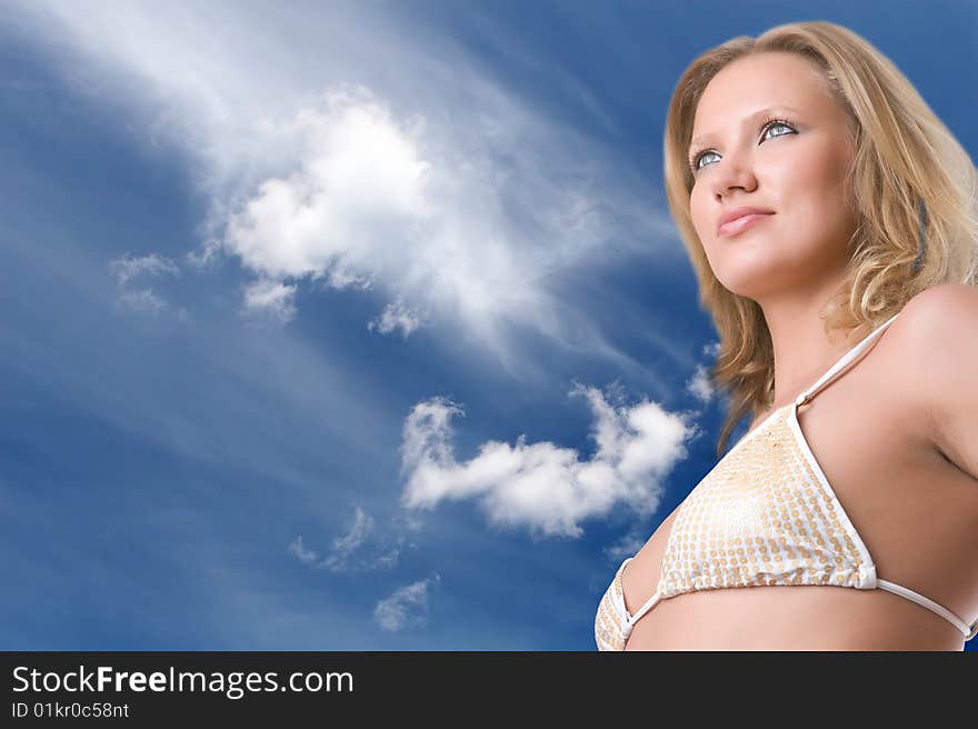 Beautiful girl in bikini against the blue sky with clouds. Beautiful girl in bikini against the blue sky with clouds