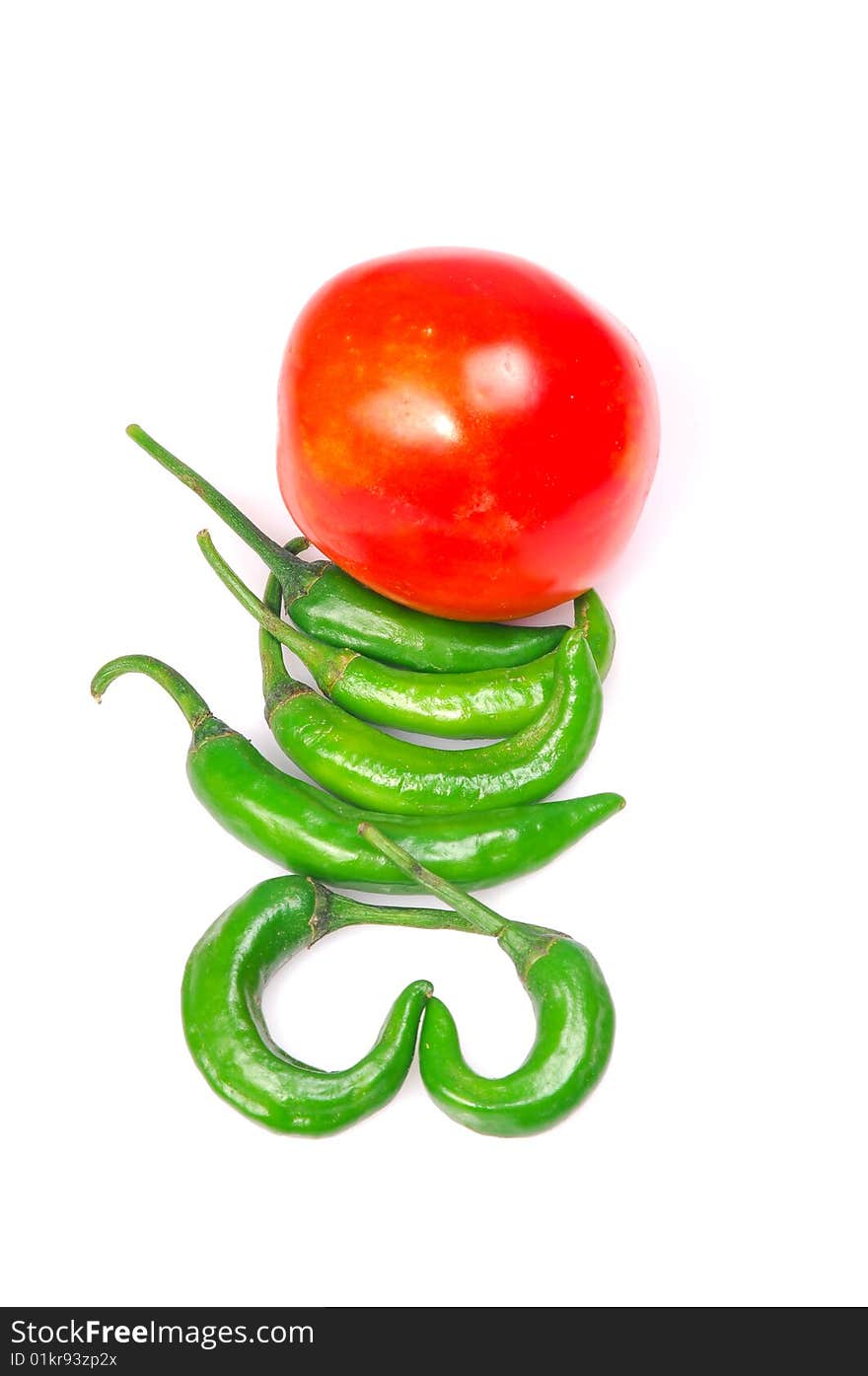 Green chillies and tomato isolated on white.