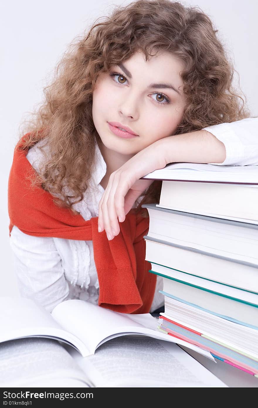 Portrait of the beautiful girl sitting at a table with textbooks