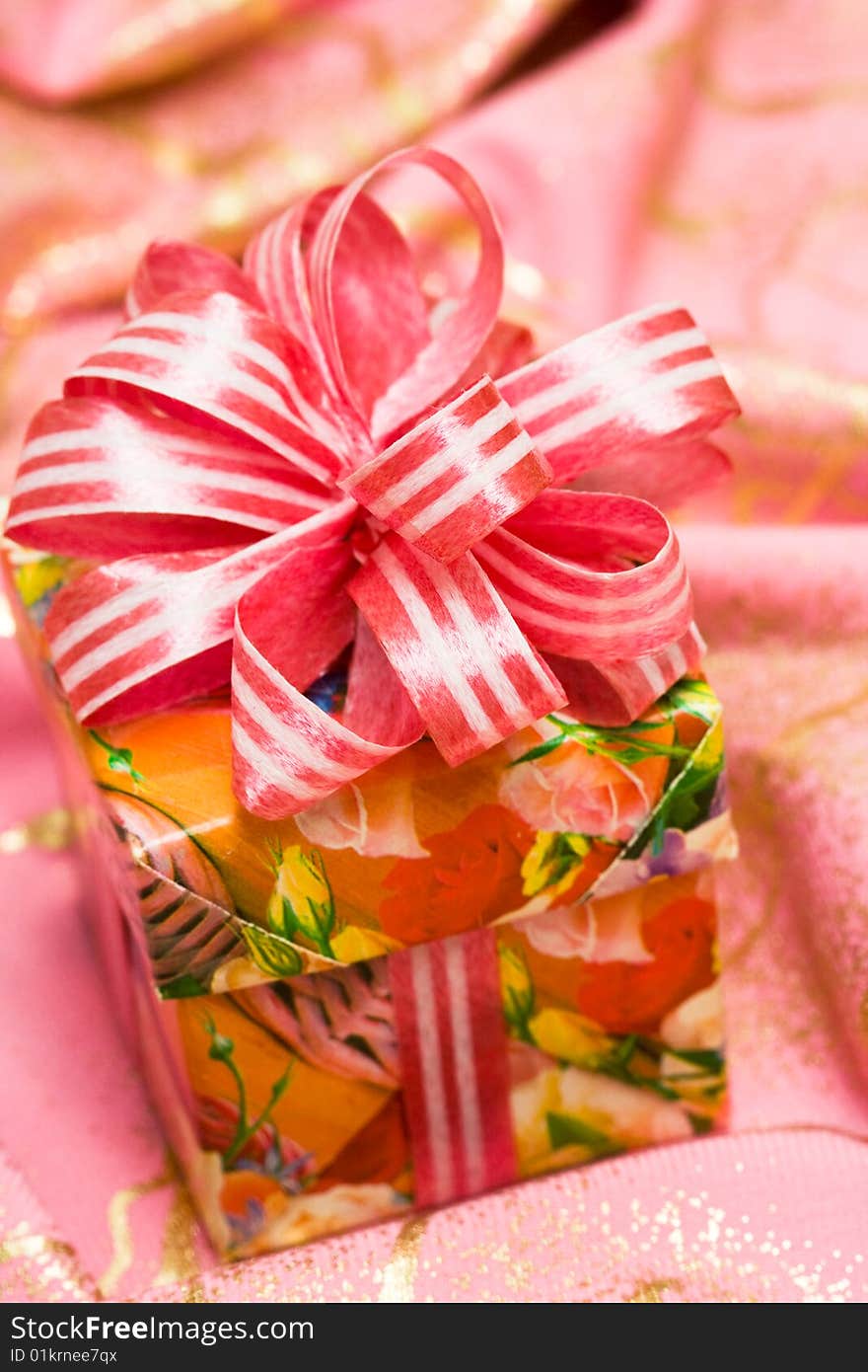 Pink gift box on silk background