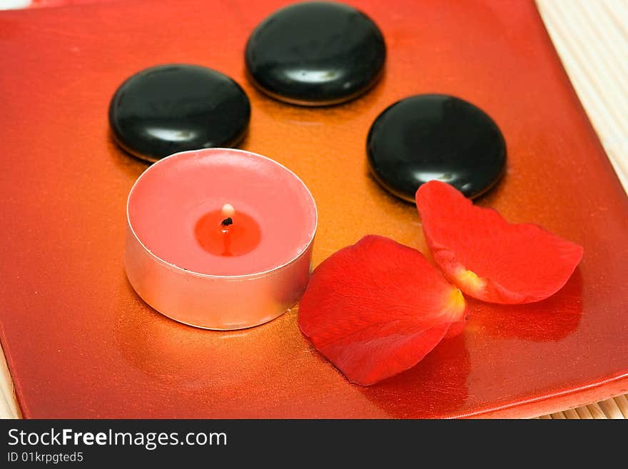 Spa essentials (candle, stones and petals of red rose)