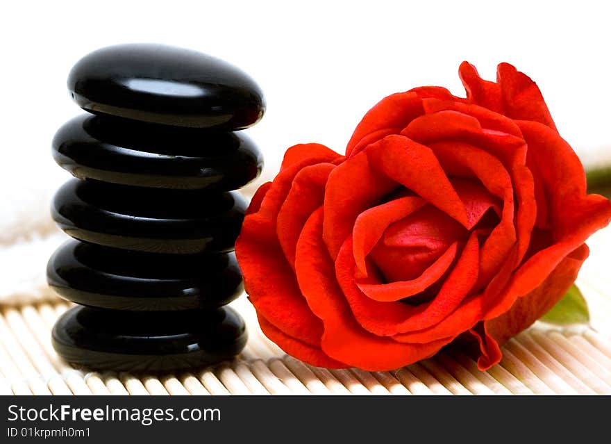 Spa essentials (pyramid of stones with white towel and rose)