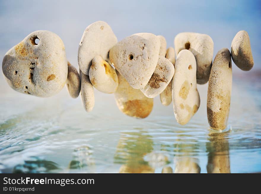 White stones joint chain  above the water. White stones joint chain  above the water