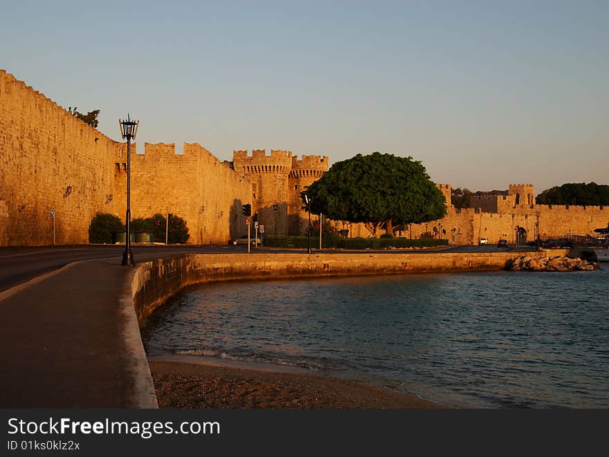 The medieval wall and harbor, Rhodes, Greece, at sunrise.