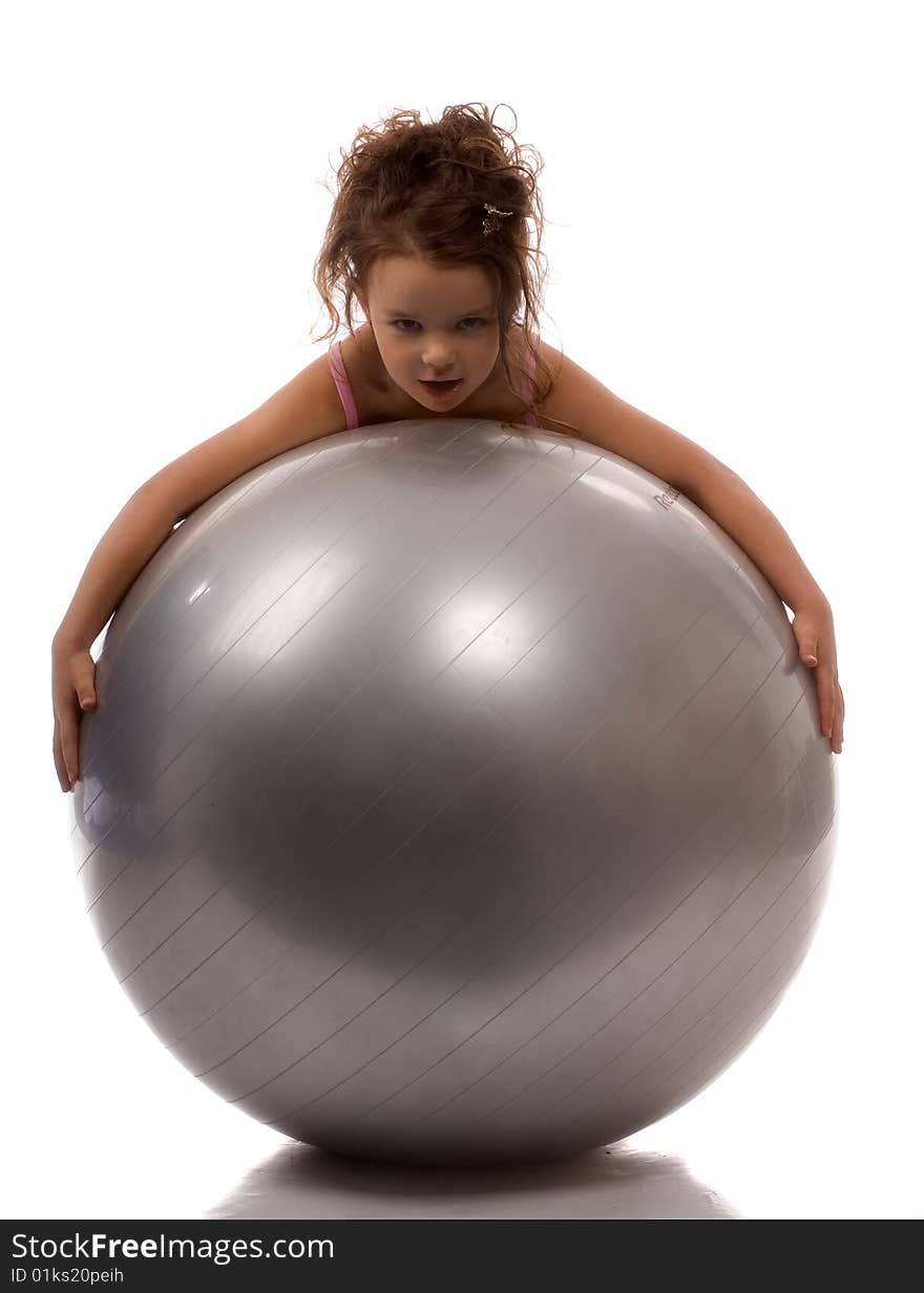 A little girl lying on a big gray ball. A little girl lying on a big gray ball