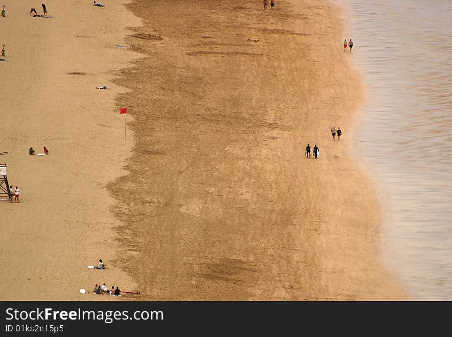 Birds perspective of beach and cost strip with surfers walking. Birds perspective of beach and cost strip with surfers walking