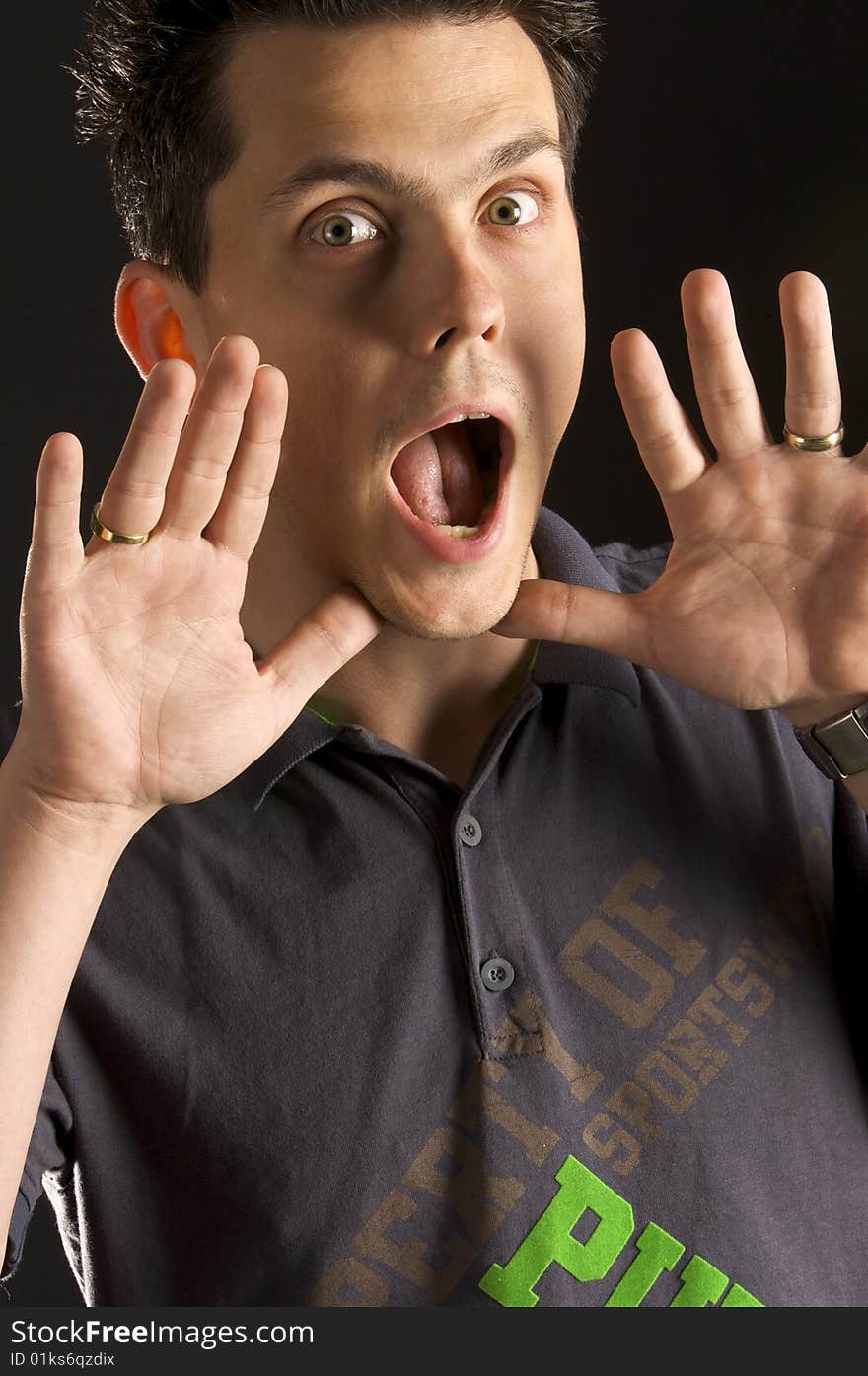 A young guy screaming with his hands near his mouth. A young guy screaming with his hands near his mouth