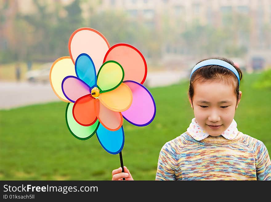 A girl with a windmill, is very funy. A girl with a windmill, is very funy