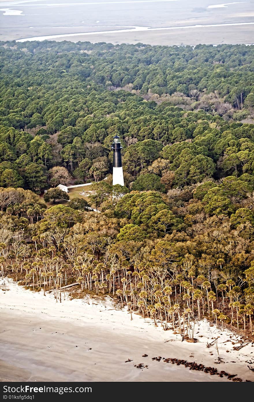 Hunting island lighthouse, built in 1859, on Hunting Island South Carolina, aerial view. The lighthouse is surrounded by maritime pine, live oak, and palmetto forest. Hunting island lighthouse, built in 1859, on Hunting Island South Carolina, aerial view. The lighthouse is surrounded by maritime pine, live oak, and palmetto forest.