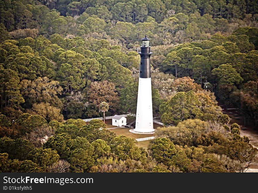 Hunting island lighthouse, built in 1859, on Hunting Island South Carolina, aerial view. The lighthouse is surrounded by maritime pine, live oak, and palmetto forest. Hunting island lighthouse, built in 1859, on Hunting Island South Carolina, aerial view. The lighthouse is surrounded by maritime pine, live oak, and palmetto forest.