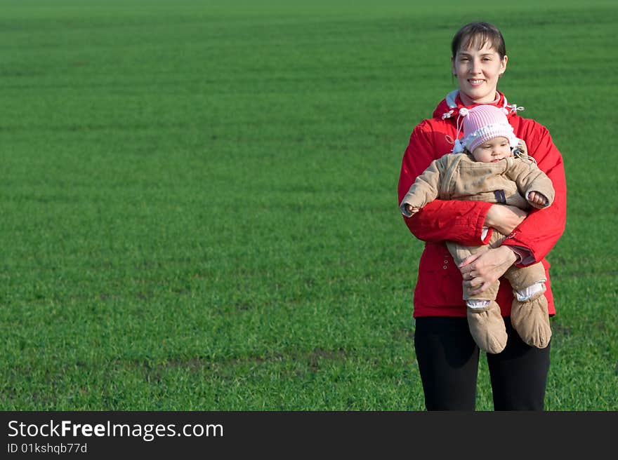 Little baby with mom on green grass background