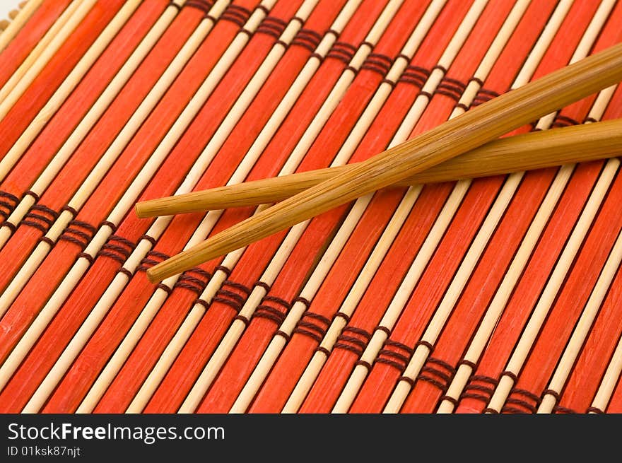 Pair of chinese chopsticks on bamboo mat. Pair of chinese chopsticks on bamboo mat.