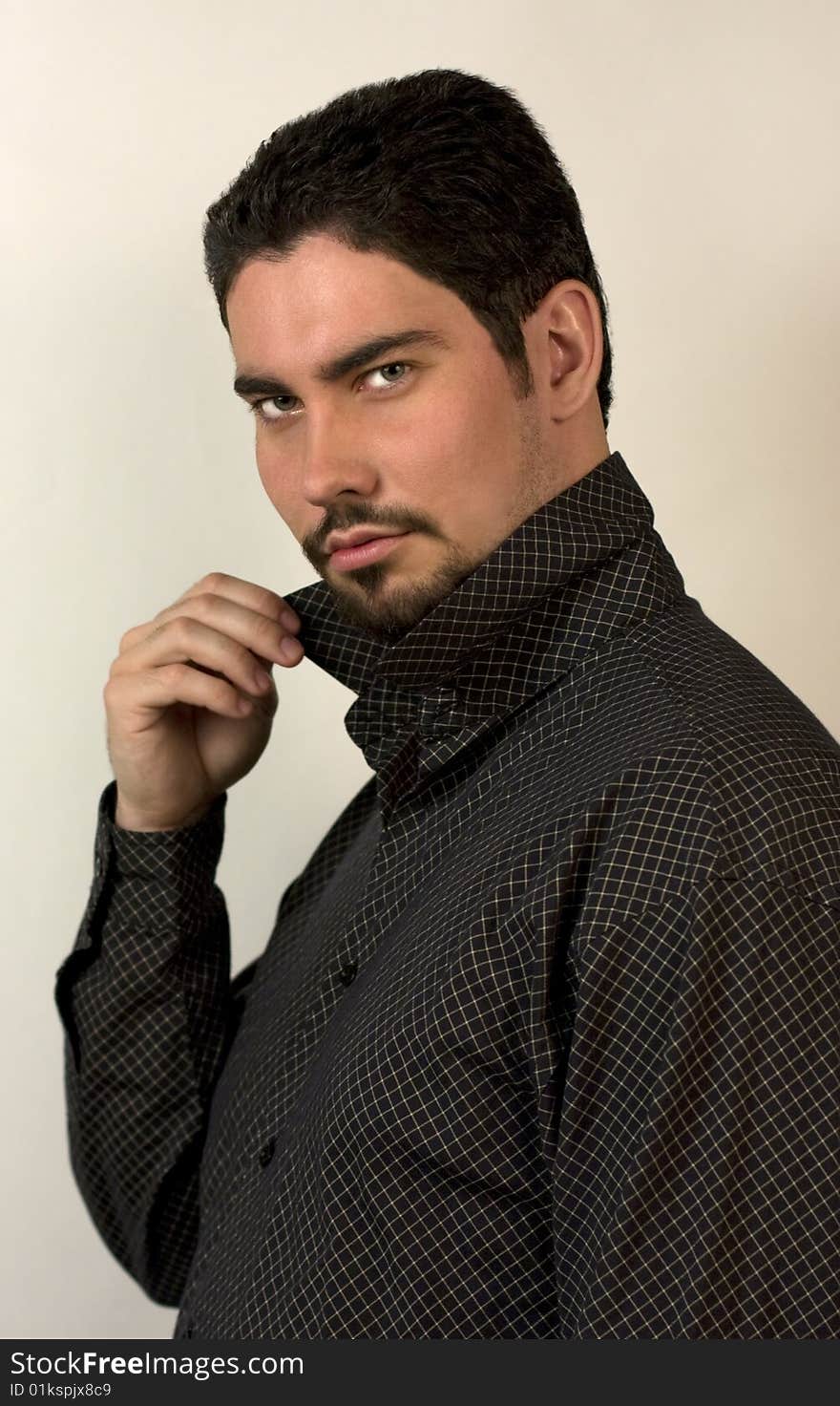 Young man in shirt, holding his collar. Young man in shirt, holding his collar