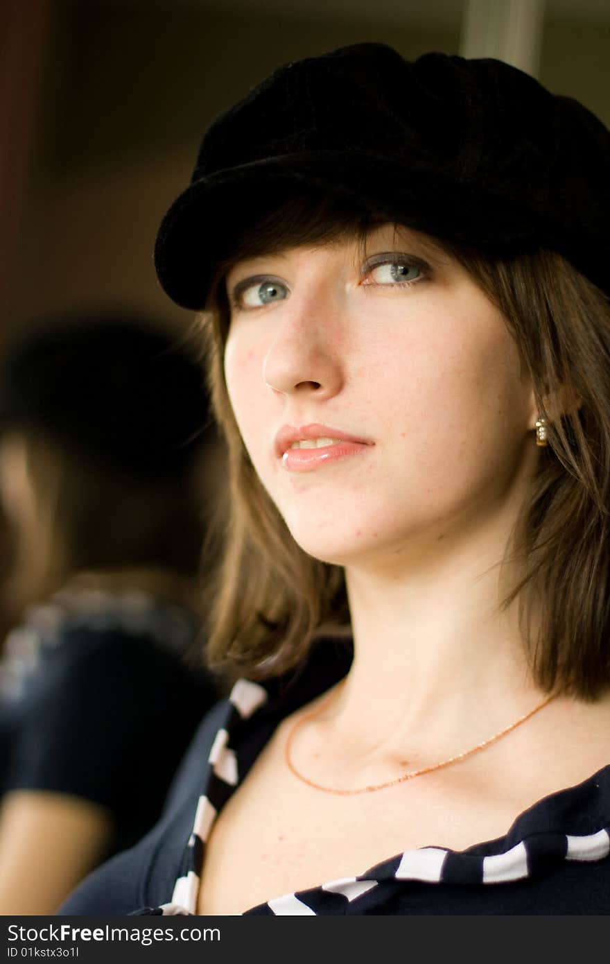 A girl in a black cap proudly looks up. A girl in a black cap proudly looks up