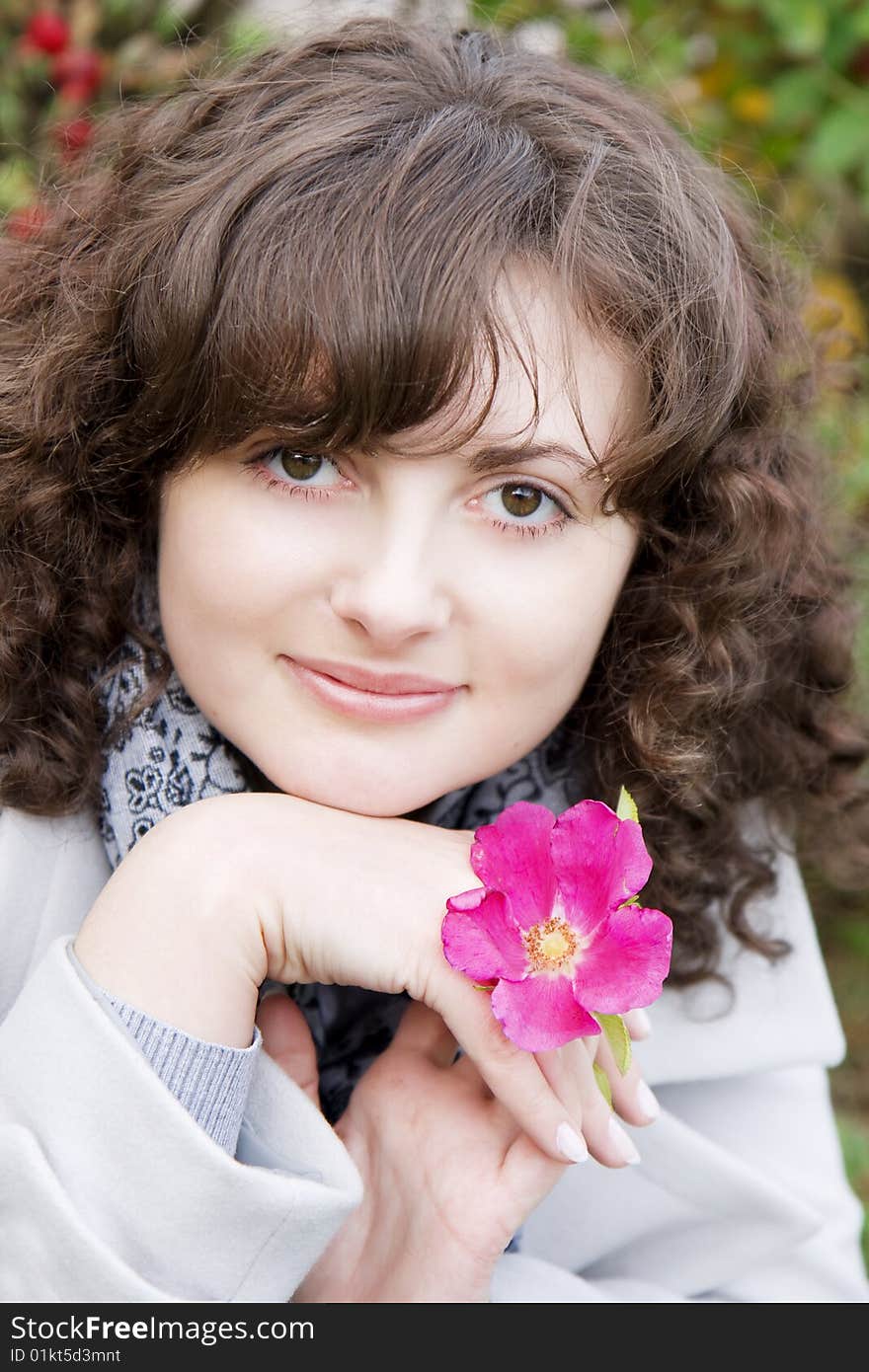 Picture of beautiful girl on a background of flowers and fruits dogrose