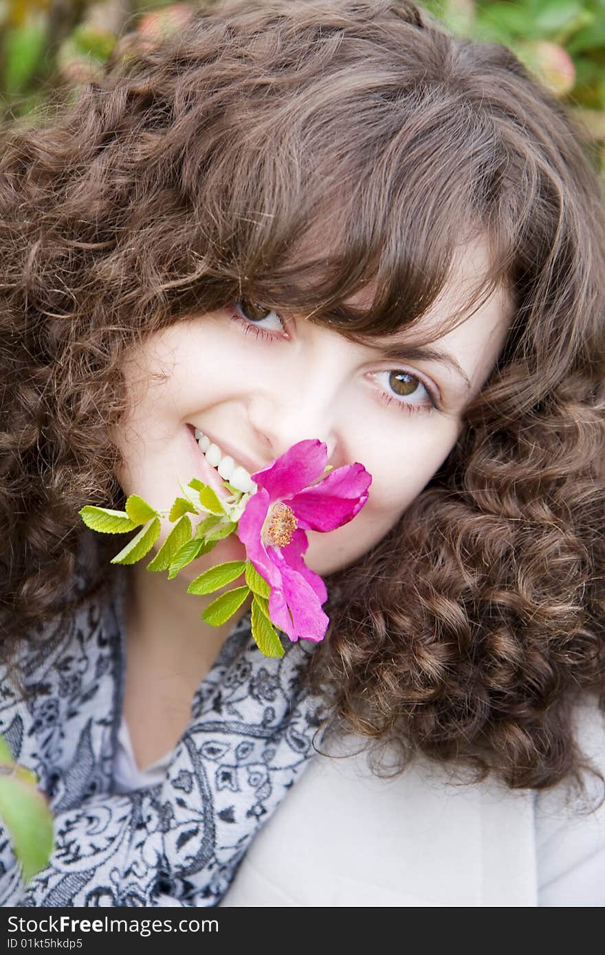 Picture of beautiful girl with a flower in your teeth dogrose. Picture of beautiful girl with a flower in your teeth dogrose