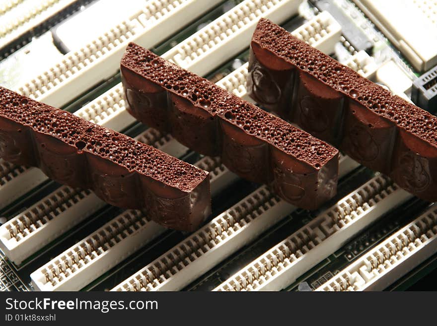 Slices of dark chocolate on a computer detail. Slices of dark chocolate on a computer detail.