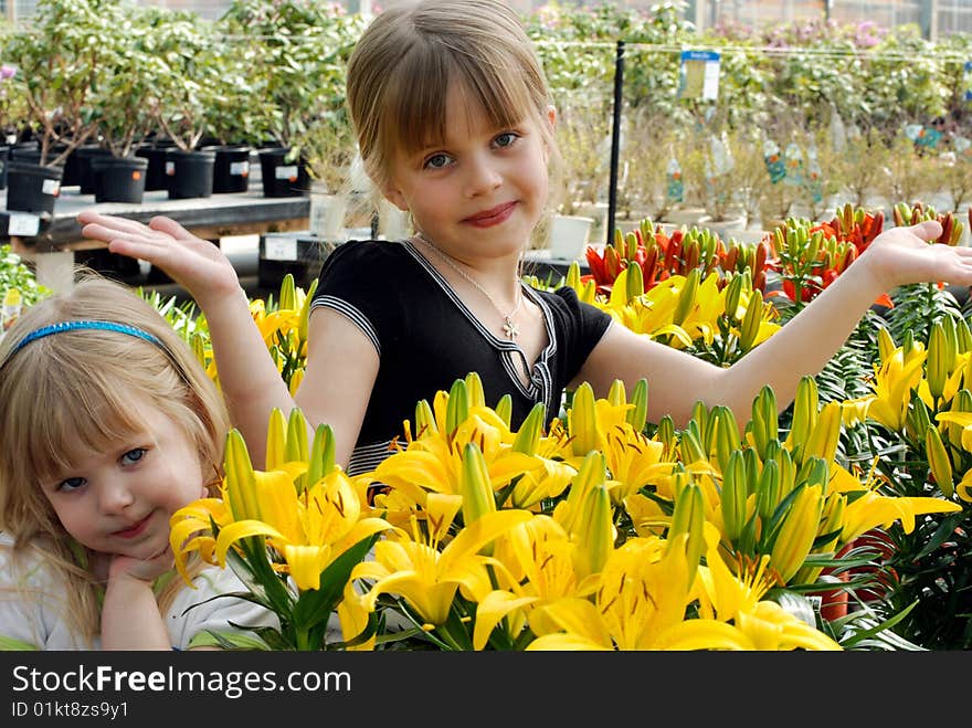 Happy sisters in a greenhouse. Happy sisters in a greenhouse.