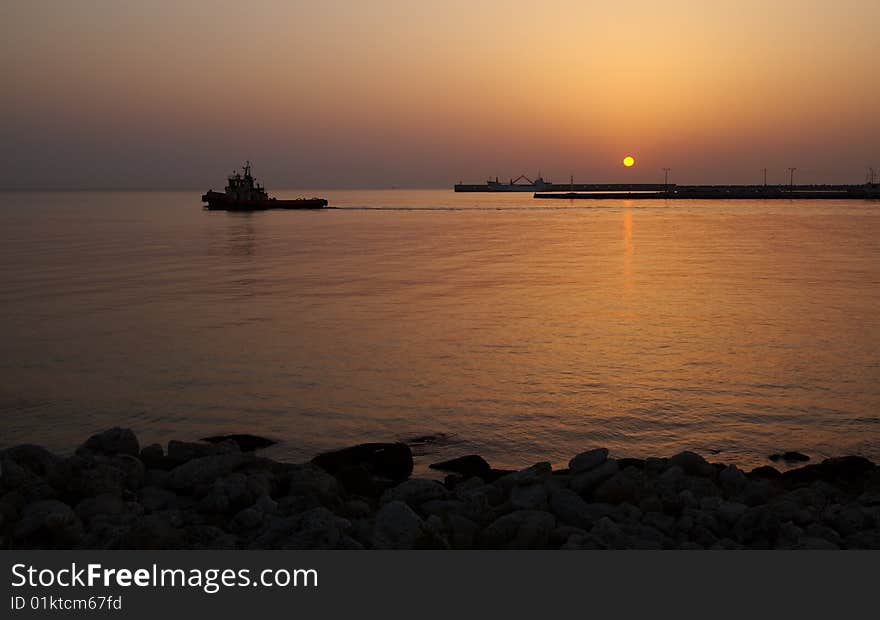 A tugboat puts out to sea at sunrise, Rhodes, Greece. A tugboat puts out to sea at sunrise, Rhodes, Greece