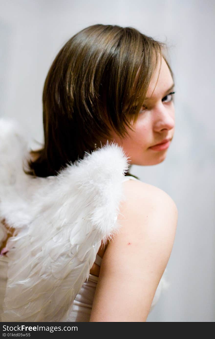 Beautiful girl with white wings behind their backs. Beautiful girl with white wings behind their backs