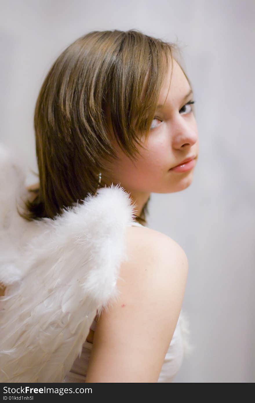 Beautiful girl with white wings behind their backs. Beautiful girl with white wings behind their backs