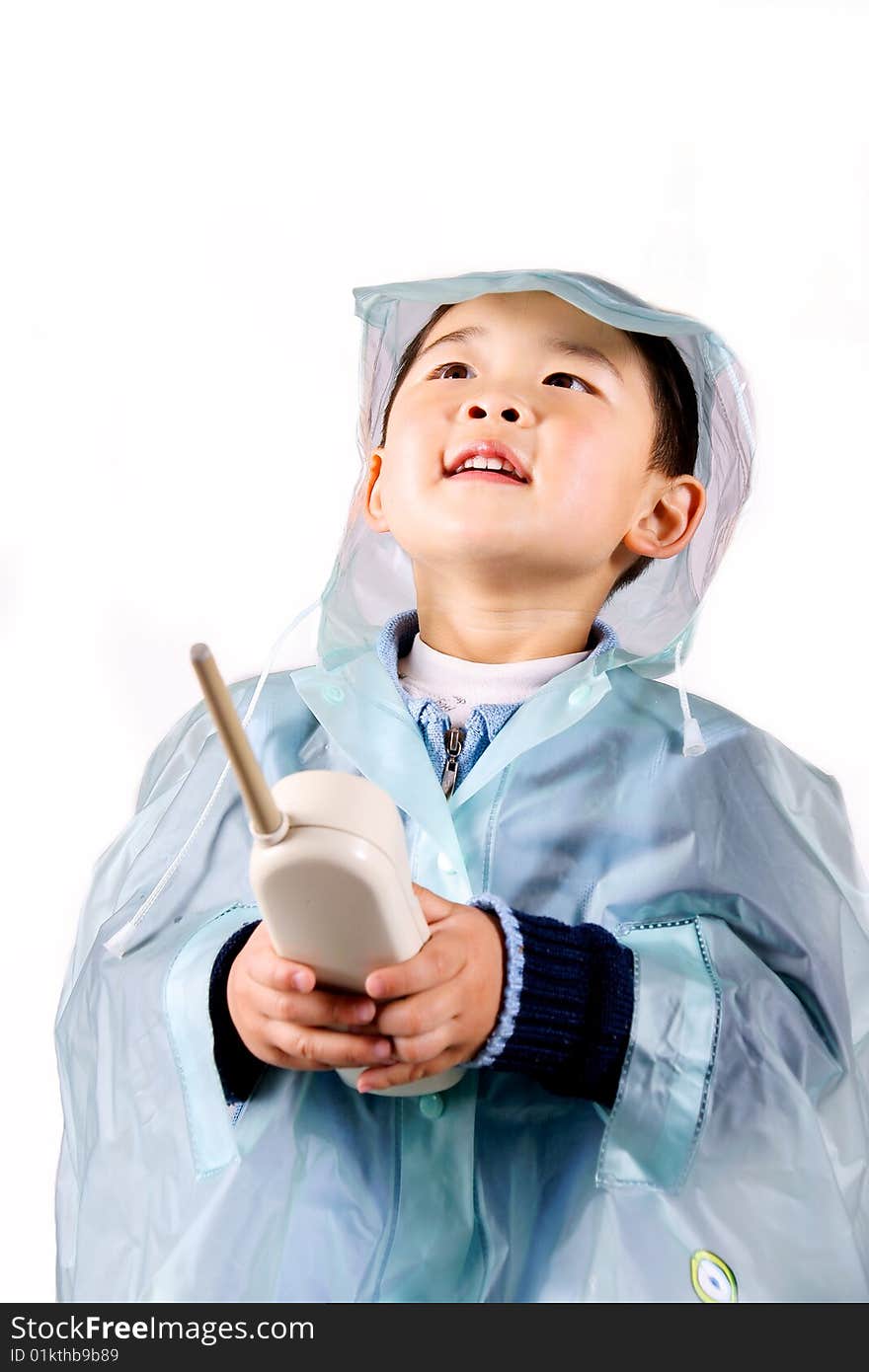 A picture of a little chinese boy holding a telephone in raincoat. A picture of a little chinese boy holding a telephone in raincoat