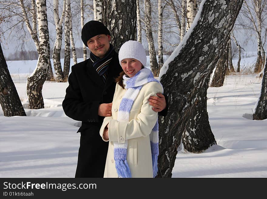 Couple the cold winter on a background of birches. Couple the cold winter on a background of birches