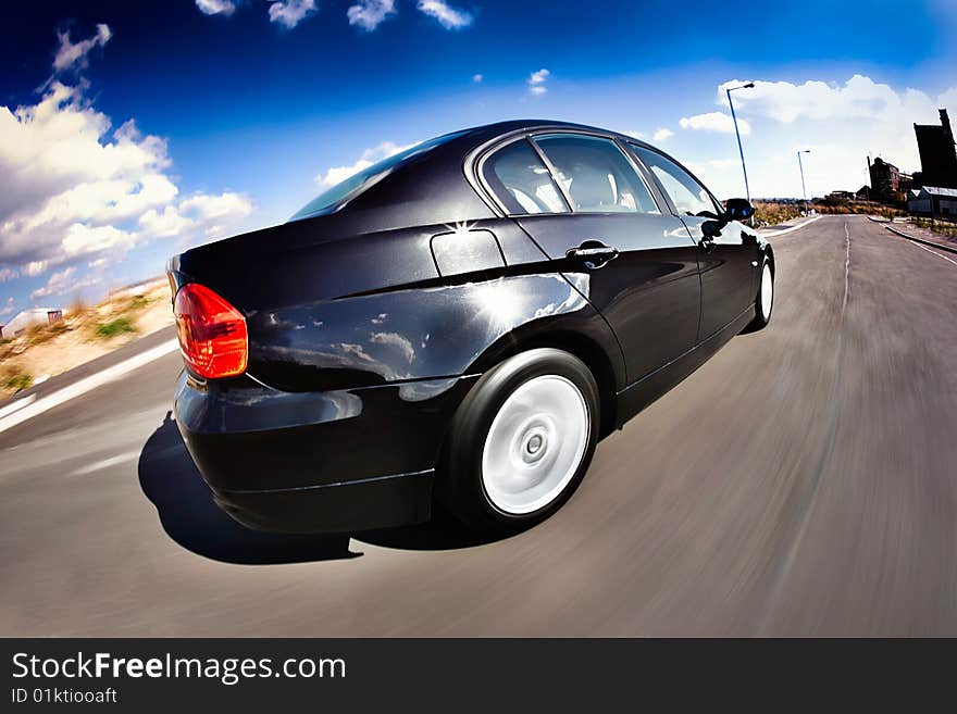 Black Sports Car in motion with deep blue sky. Black Sports Car in motion with deep blue sky