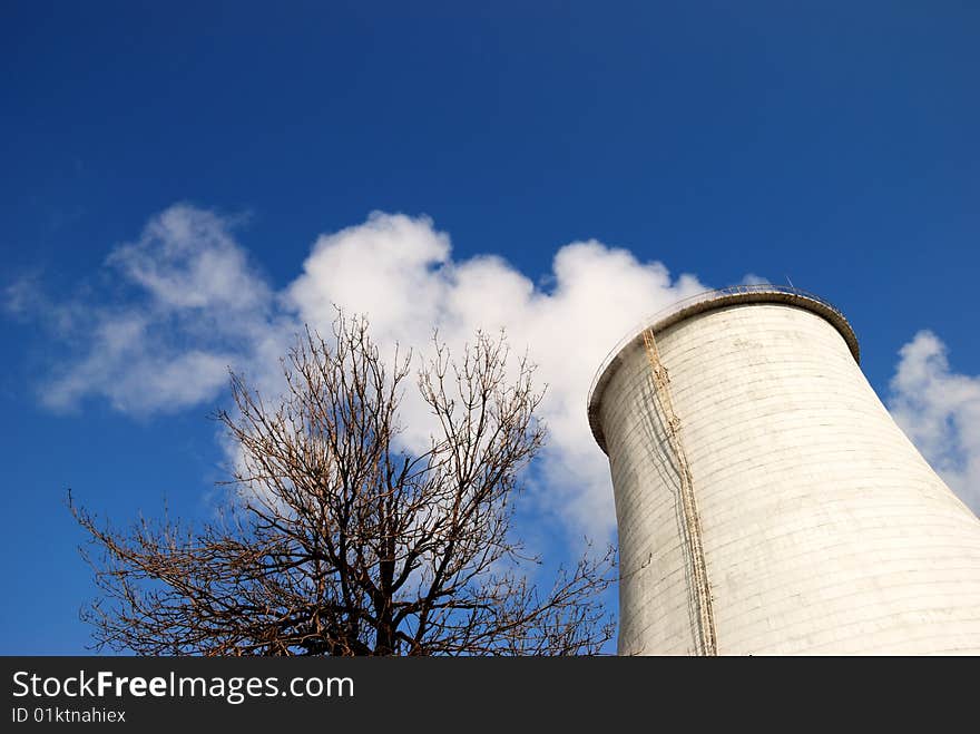 Smoking pipe and tree against the blue sky