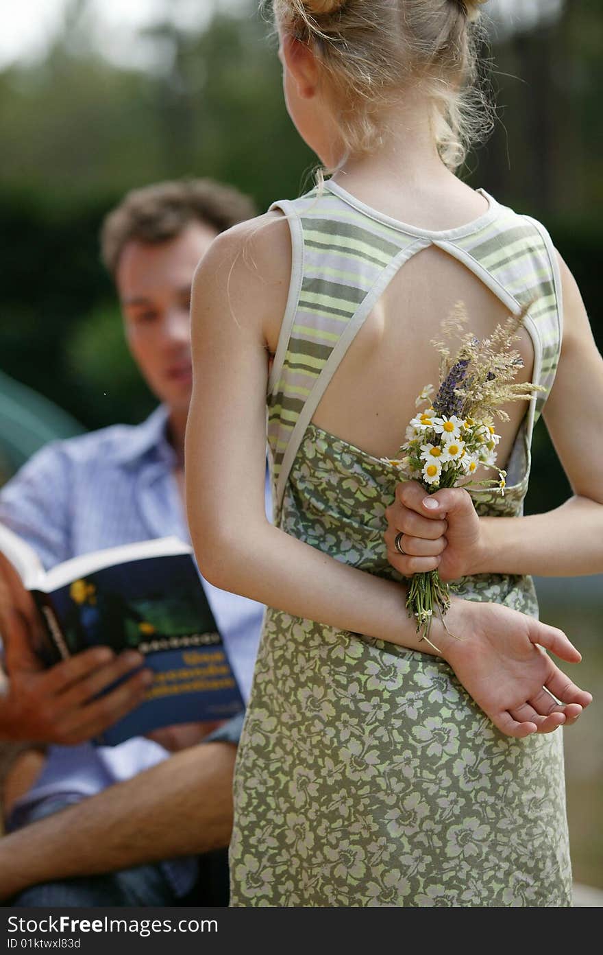 Young girl about to surprise her dad with flowers. Young girl about to surprise her dad with flowers