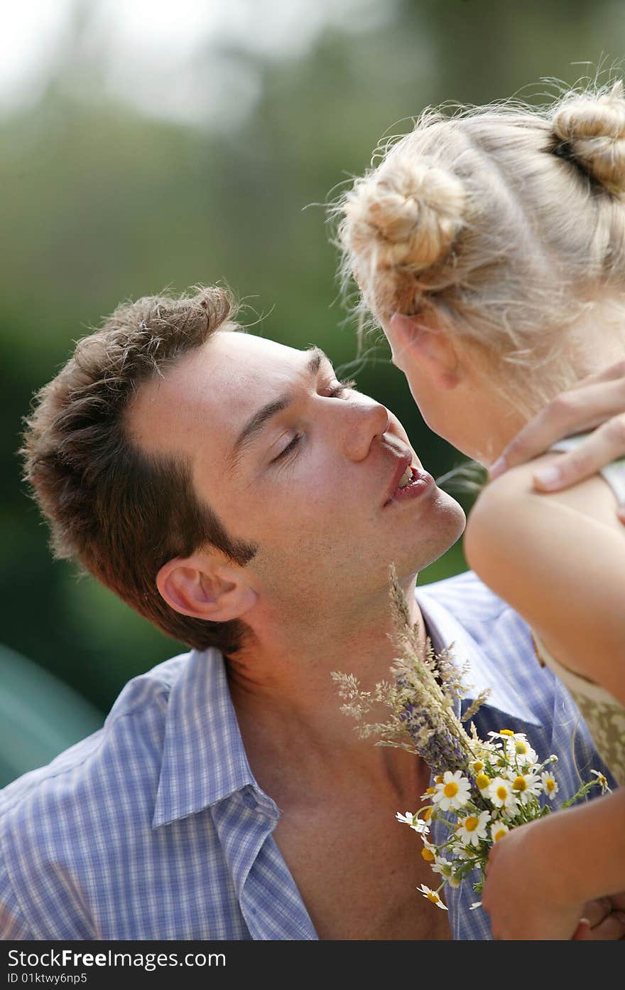 Young dad thanking his daughter for giving him a bouquet of flowers. Young dad thanking his daughter for giving him a bouquet of flowers