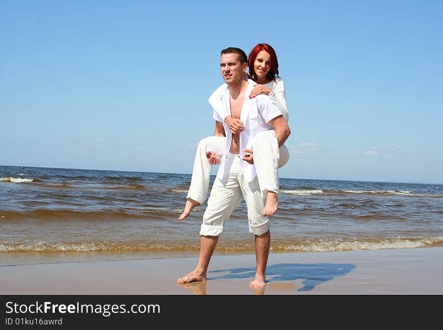 Beautiful yound couple relaxing on the beach. Beautiful yound couple relaxing on the beach