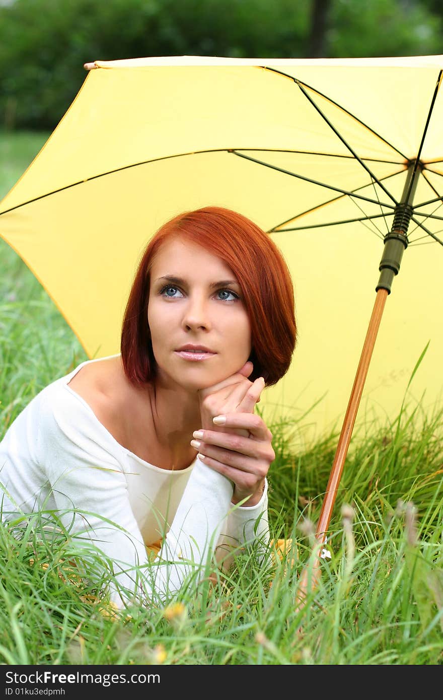 Beautiful girl relaxing on grass under yellow umbrella. Beautiful girl relaxing on grass under yellow umbrella