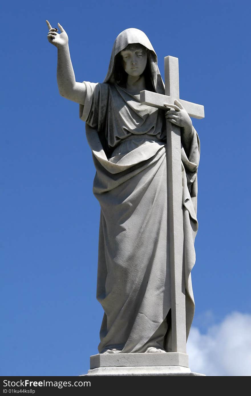 Marble statue with cross on the blue skies