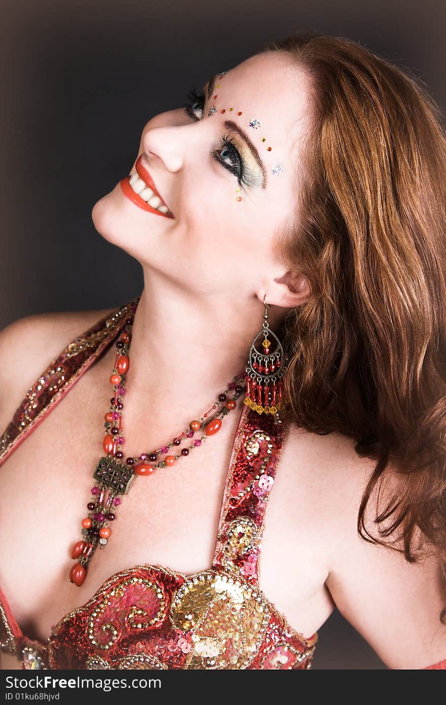 Belly Dancer wearing a red costume with jewelery. Belly Dancer wearing a red costume with jewelery