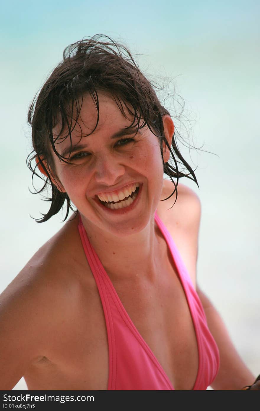 Woman in pink bikini at the beach smiling. Woman in pink bikini at the beach smiling