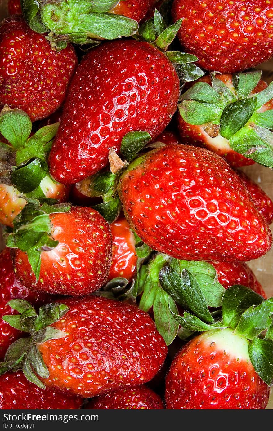 Macro image of fresh strawberries with leaves.