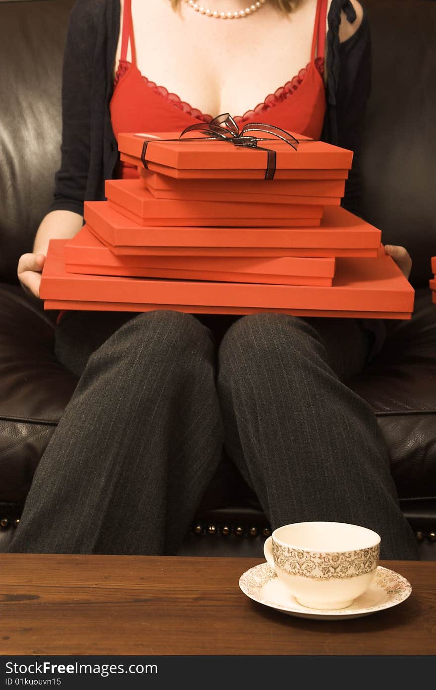 A stack of red gift boxes, the top one tied with black ribbon. A stack of red gift boxes, the top one tied with black ribbon