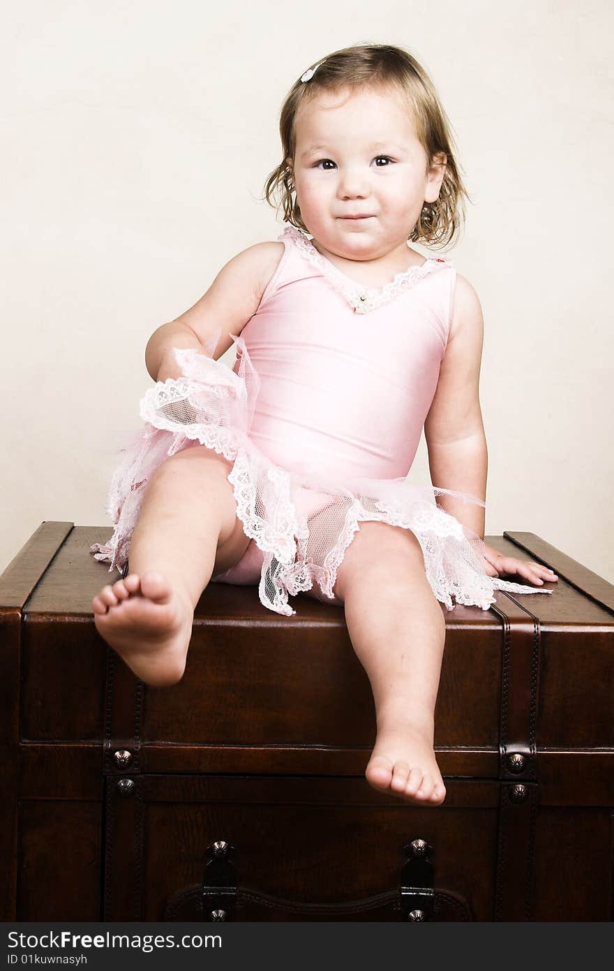 Little girl with short hair wearing a pink ballet outfit