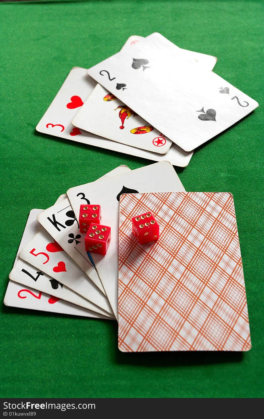 Cards and joker on the green background