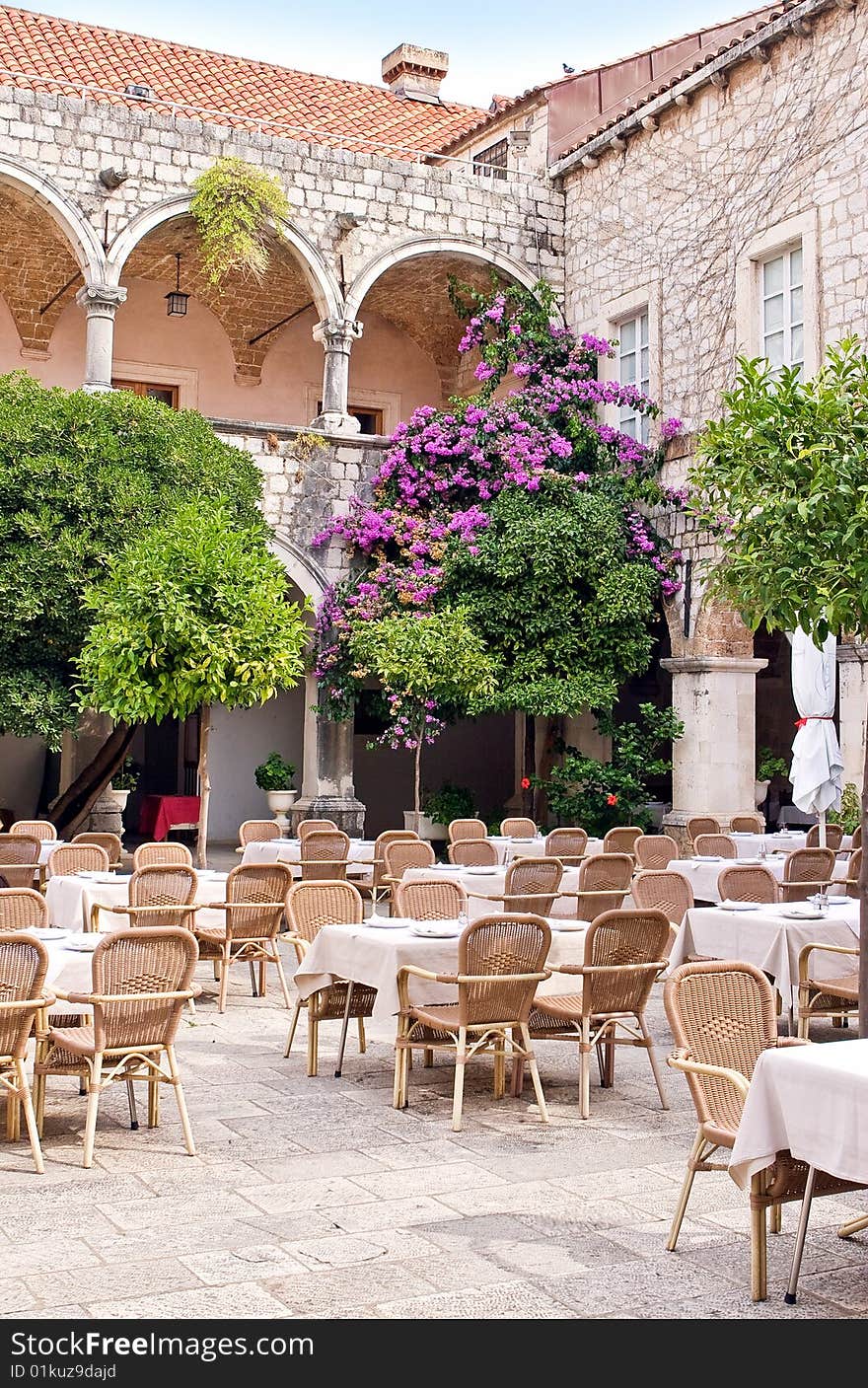 Green courtyard with wood furniture