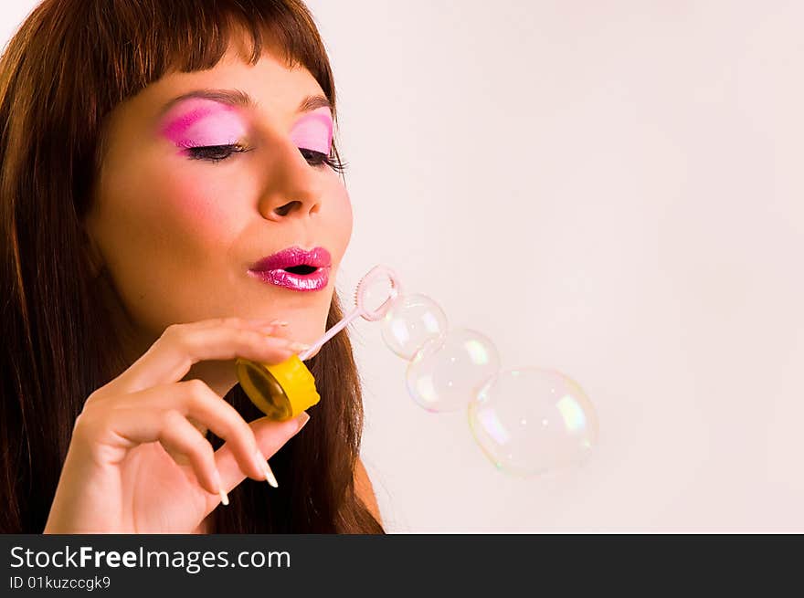 The  girl starts up soap bubbles close up. The  girl starts up soap bubbles close up