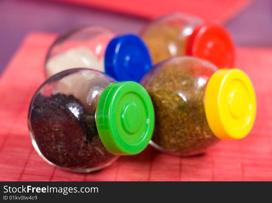 Four glass jars with spices and color covers