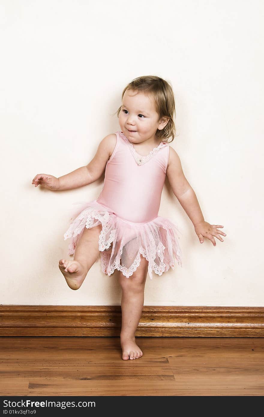 Little girl with short hair wearing a pink ballet outfit