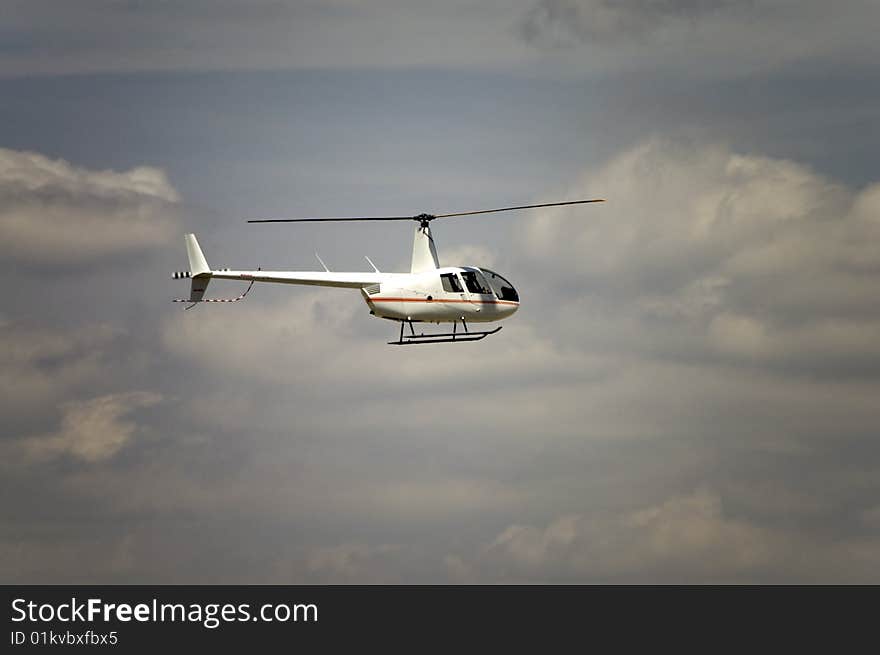 A four passenger helicopter flying through a cloudy sky. A four passenger helicopter flying through a cloudy sky.