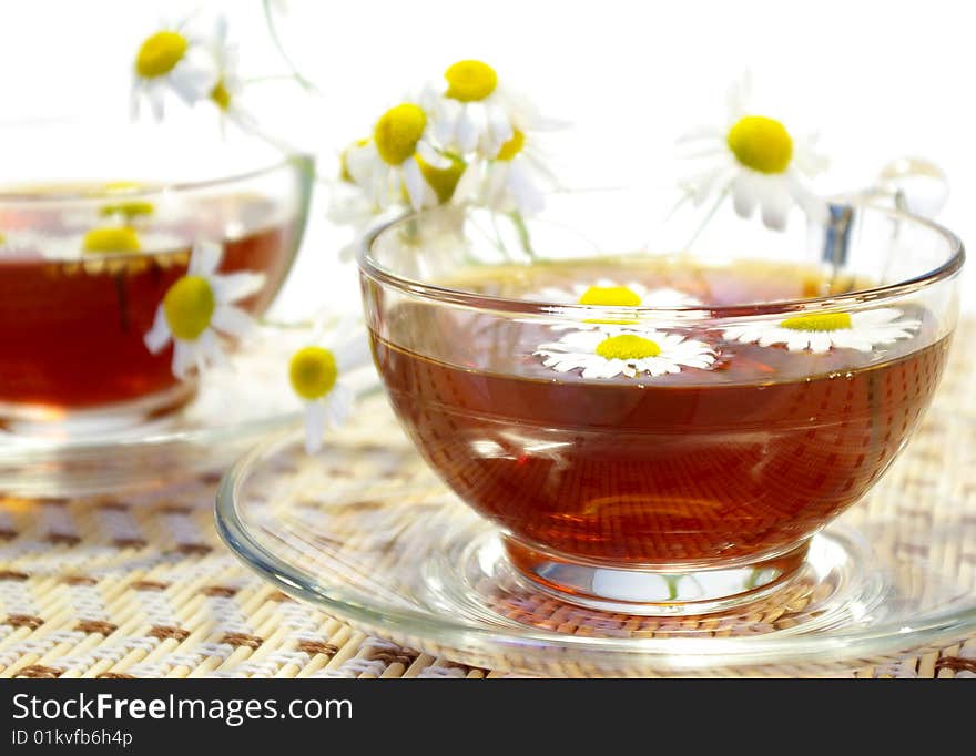 Cups of tea and chamomile blossoms