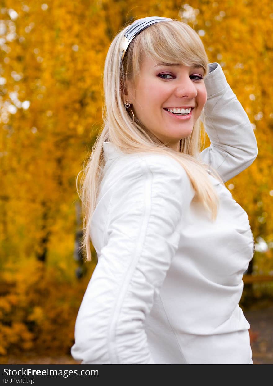 Pretty girl adjusting her hair - autumn park background - shallow DOF