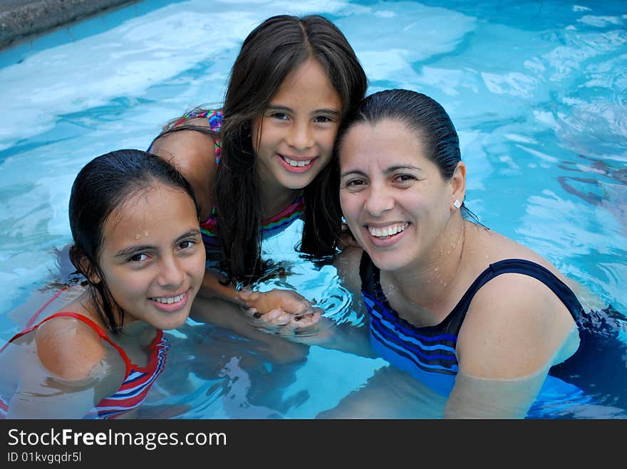 Mother with her beautiful  daughters in  the pool.