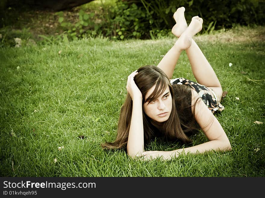 Young thoughtful woman laying on the grass. Young thoughtful woman laying on the grass